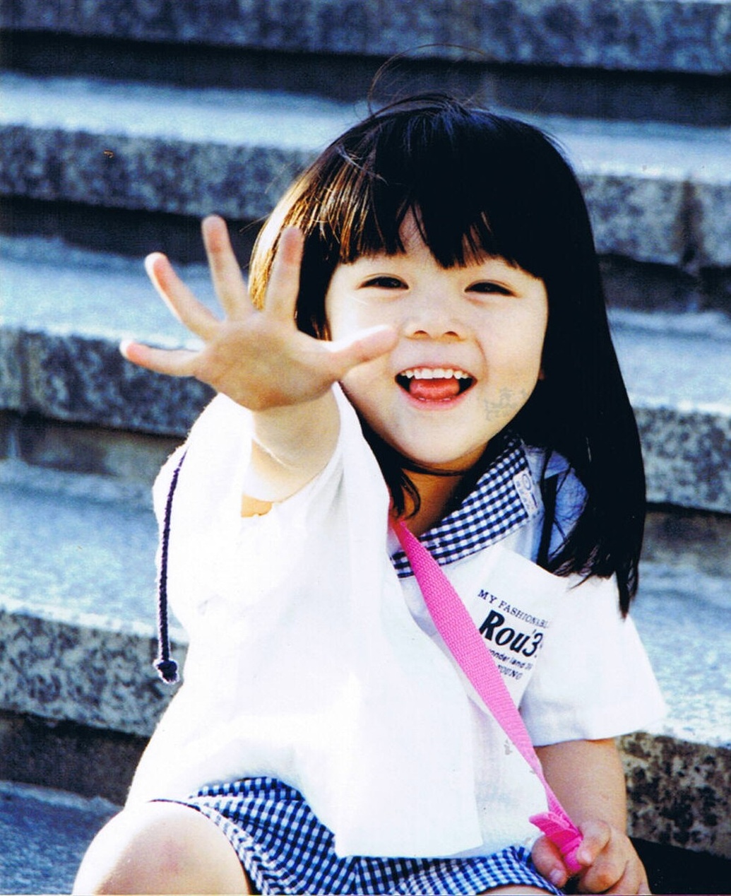 Een lachend Japans meisje in schattige, eigentijdse kindermode.